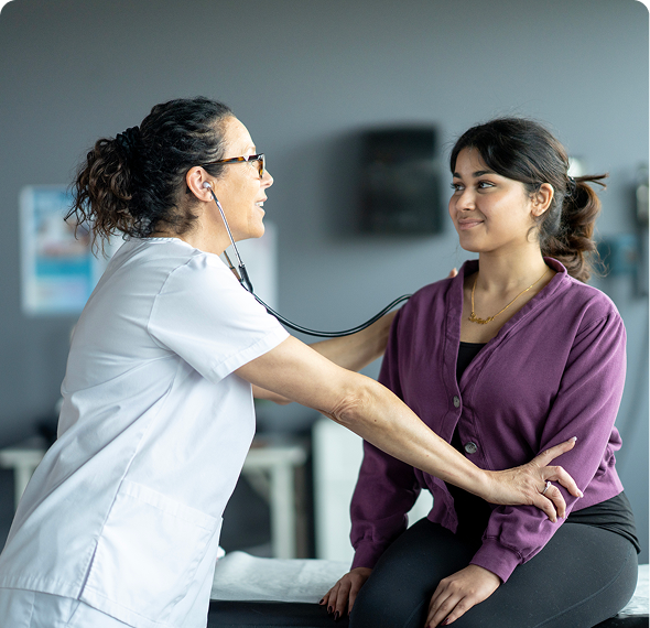Doctor using stethoscope on patient's back